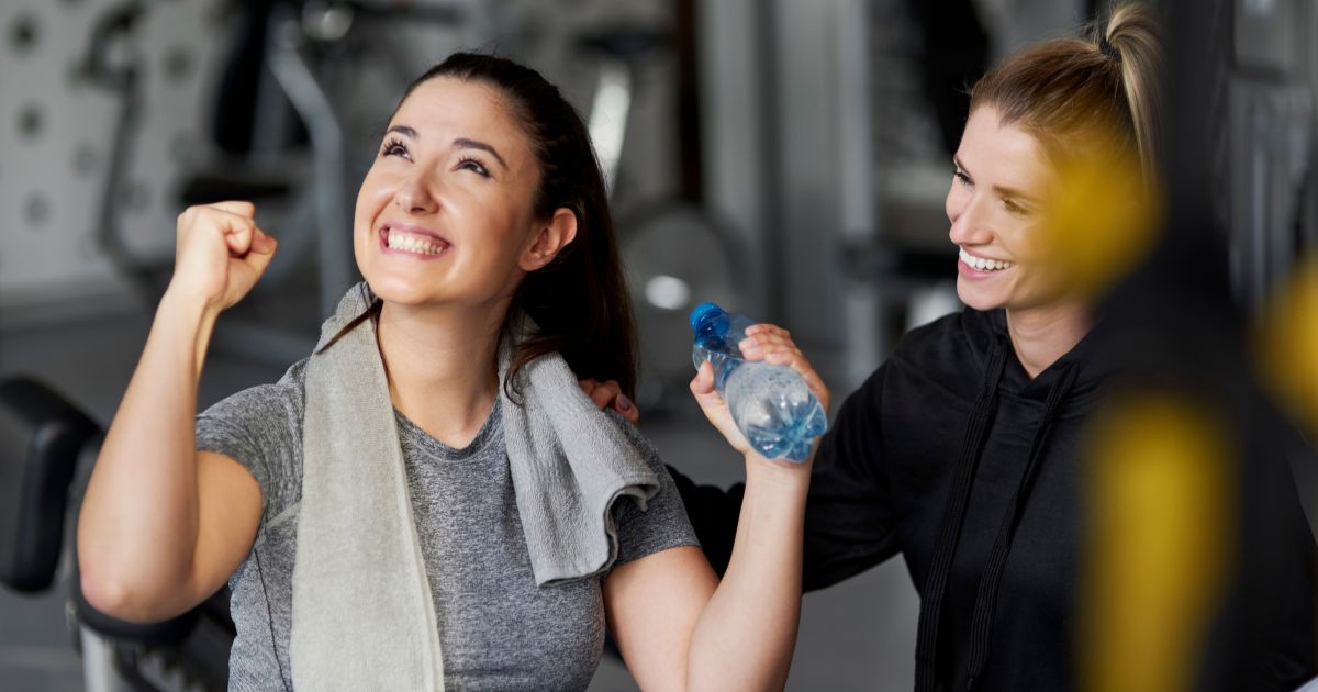 A person celebrating in a gym next to their coach
